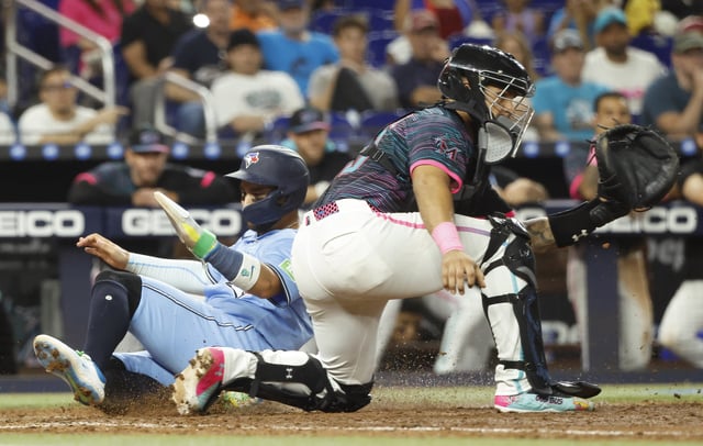 Aug 23, 2025; Miami, Florida, USA; Toronto Blue Jays shortstop Bo  Bichette (11) scores against the Miami Marlins catcher Agustin Ramirez (50) during the tenth inning at loanDepot Park. Mandatory Credit: Rhona Wise-Imagn Images