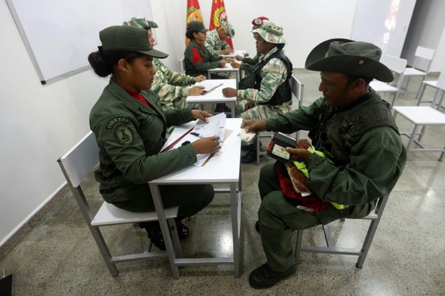 Des personnes s'inscrivent pour rejoindre les forces militaires lors d'une campagne nationale d'enrôlement lancée par le président Nicolas Maduro, le 23 août 2025 à Caracas