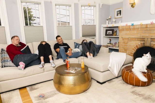 Tristan Storm, left, and Calder Storm hang out with their children in their living room in San Francisco on Friday.