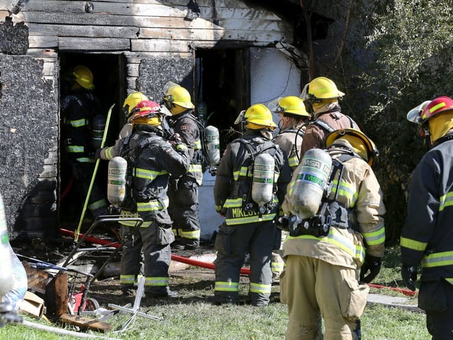 Firefighters gathered at a house on Union Avenue West in Winnipeg on Sunday, Sept. 25, 2022. A fire broke out at the home at about 8 a.m., with firefighters returning at about 11:30 a.m. after it reignited. 