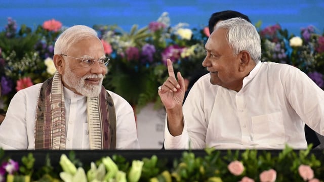 Prime Minister Narendra Modi (L) speaks with Nitish Kumar, Chief Minister of Bihar, during a public meeting in Gaya in Bihar on August 22. (Photo by Sachin KUMAR / AFP)