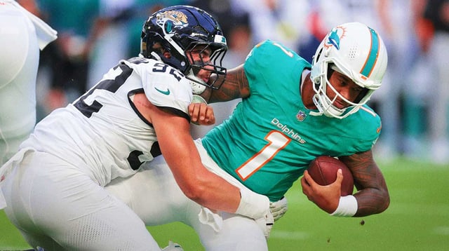 Aug 23, 2025; Miami Gardens, Florida, USA; Jacksonville Jaguars defensive end Danny Striggow (92) tackles Miami Dolphins quarterback Tua Tagovailoa (1) during the first quarter at Hard Rock Stadium. Mandatory Credit: Sam Navarro-Imagn Images