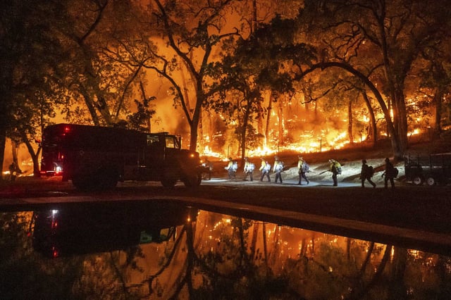 Firefighters battle the Pickett Fire in the Aetna Springs area of Napa County on Saturday.