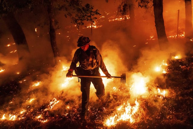 A firefighter battles the Pickett Fire in the Aetna Springs area of Napa County on Saturday.