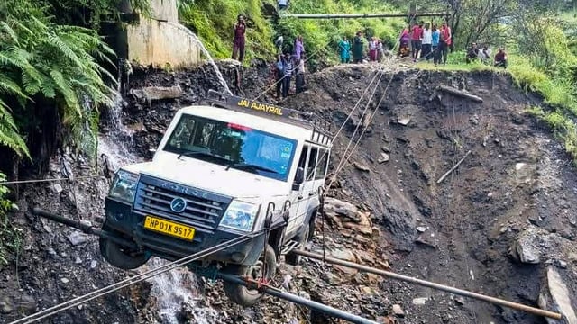 A vehicle being lifted from the debris of a damaged road after heavy rainfall, in Kullu district, Himachal Pradesh on Saturday, August 23, 2025. 