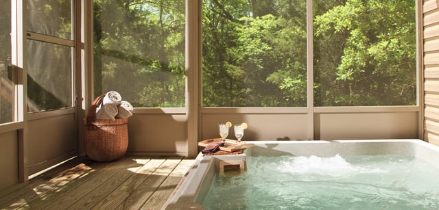 Stock image of indoor hot tub enclosed by screens.