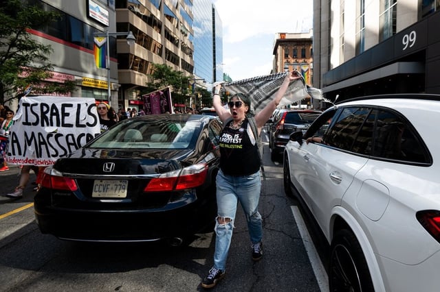A Pro-Palestine protester chants as they walk through blocked traffic following the annual Capital Pride Parade in Ottawa, on Sunday, Aug. 24, 2025. THE CANADIAN PRESS/Spencer Colby