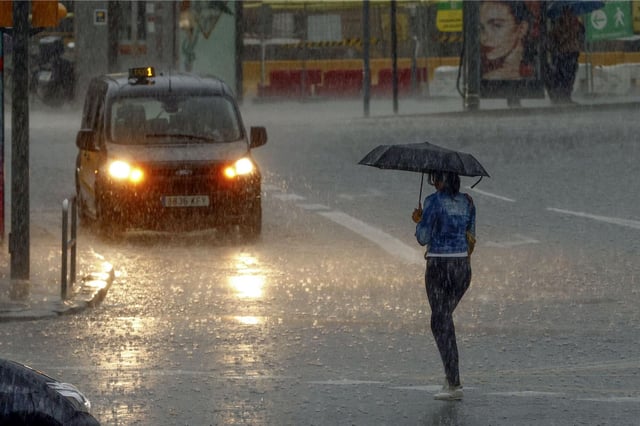 Persona caminando bajo la lluvia en Barcelona.