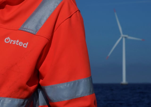 The logo for Orsted can be seen on the jacket worn by an employee as he talks to journalists during a visit to the offshore wind farm near Nysted, Denmark, September 4, 2023. REUTERS/Tom Little/File Photo