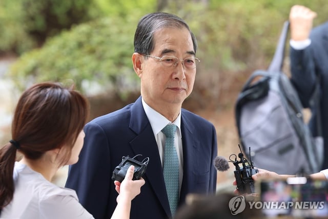 Former Prime Minister Han Duck-soo (R) arrives at the Seoul High Prosecutors Office in Seoul on Aug. 22, 2025, to undergo questioning by special counsel Cho Eun-suk's team over his alleged involvement in former President Yoon Suk Yeol's botched imposition of martial law. (Yonhap)