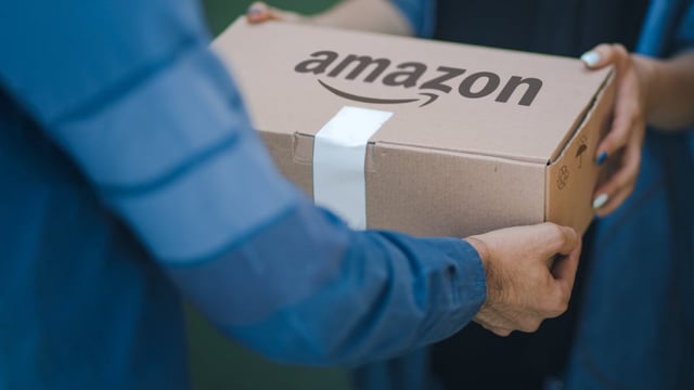 Ein Amazonpaket wird überreicht. (Foto: No-Mad / Shutterstock)