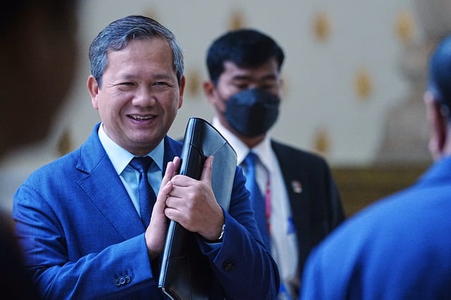 Cambodian Prime Minister Hun Manet, left, greets lawmakers as he arrives at the session on the draft law on amending the law on nationality at the National Assembly in Phnom Penh Cambodia, Monday, Aug. 25, 2025. (AP Photo/Heng Sinith)