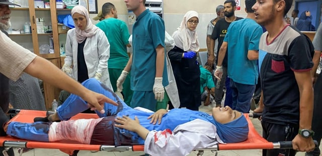 Des Palestiniens transportent une infirmière blessée par de meurtrières frappes israéliennes sur l'hôpital Nasser, à Khan Younès, dans le sud de la bande de Gaza, le 25 août 2025