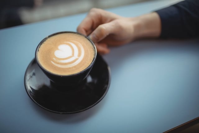 Hand of male executive holding coffee cup in cafeteria || Modellfreigabe vorhanden / Mindestpreis 20 Euro