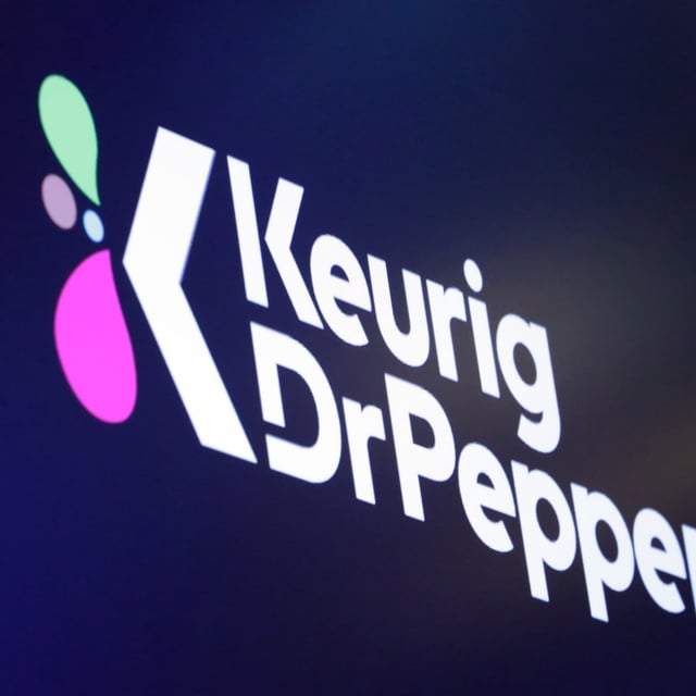 FILE - The logo for Keurig Dr. Pepper appears above a trading post on the floor of the New York Stock Exchange, July 12, 2018. (AP Photo/Richard Drew, File)