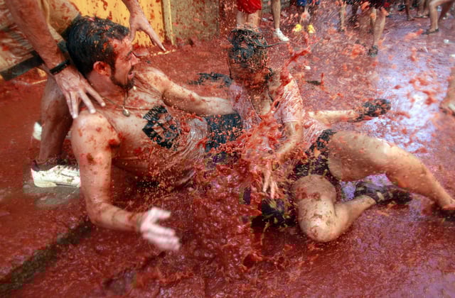 FILE - Revelers play with tomato pulp during the annual "Tomatina" tomato fight fiesta in Bunol, near Valencia, Spain, Aug. 29, 2012. (AP Photo/Alberto Saiz, File)