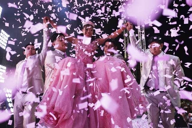 Confetti falls over Isela Santiago Morales during her 15th birthday party at a stadium in Axtla de Terrazas, Mexico, Saturday, Aug. 23, 2025, organized by the community after her father's social media appeal drew support following her first sparsely attended celebration. (AP Photo/Mauricio Palos)