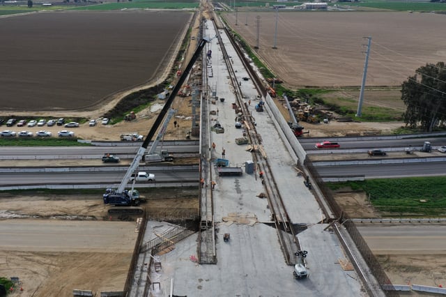 An aerial image shows construction workers building the Hanford Viaduct over Highway 198 and past agricultural fields as part of the California High Speed Rail (CAHSR) transit project in Hanford, California, on February 12, 2025.