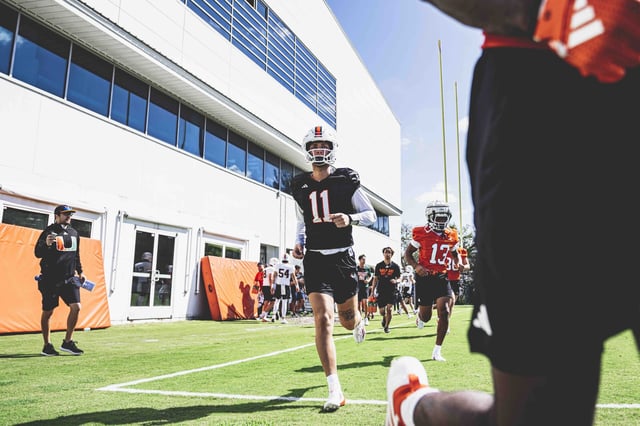 QB Carson Beck jogging onto the field for a scrimmage. Photo by Mikayla Oliveira, University of Miami Athletics