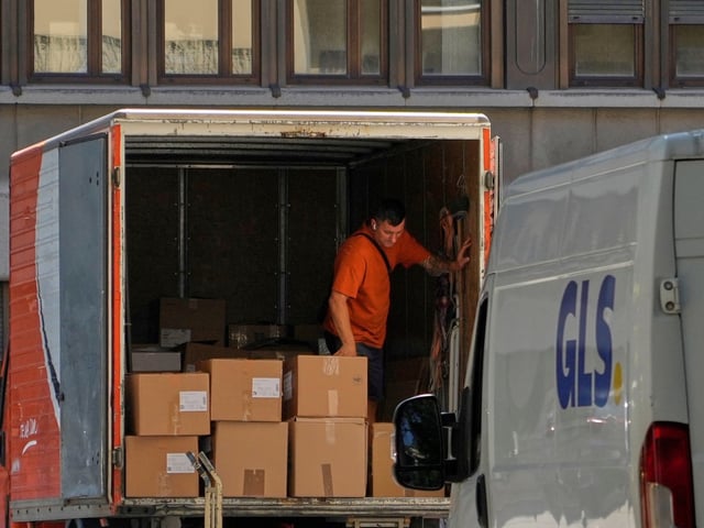 A man stands inside a truck with loaded with boxes outside an Italian Post service office in Rome, Monday, Aug. 25, 2025, which has announced, as others European services it temporary suspended the handling of parcel posts towards the United States starting Aug. 29. (AP Photo/Gregorio Borgia)