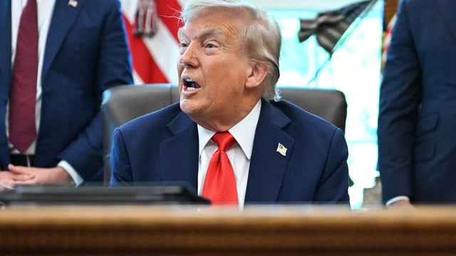 US President Donald Trump speaks to the press after signing some orders in the Oval Office of the White House in Washington on August 25.