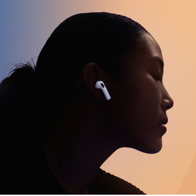 woman wearing Apple AirPods 4 with colorful backdrop