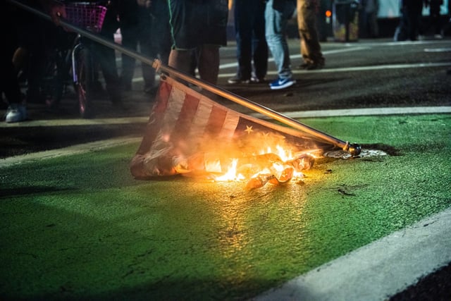 Protesters burn an American flag in Portland, Oregon, on Nov. 4, 2020, during a demonstration organized by Black Lives Matter, a day after the presidential election. Democrat contender Joe Biden neared the 270 electoral votes needed to win the White House with several battleground states still in play, as incumbent President Donald Trump challenged the vote count.