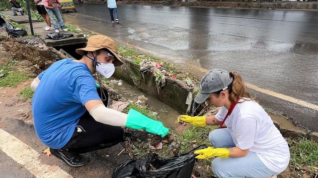 Foreign nationals during a cleanliness drive to clean roads and drains, in Gurugram on Monday. (@ANI X)
