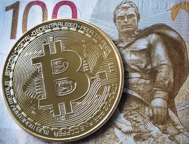 A souvenir bitcoin token is seen pictured with a 100 ruble bill in Moscow on July 30, 2024. Russian lawmakers voted on July 30, 2024 to tighten rules on petrocurrency mining, while also paving the way for it to be used in cross-border payments as a means to skirt Western sanctions. (Photo by Alexander NEMENOV / AFP) (Photo by ALEXANDER NEMENOV/AFP via Getty Images)