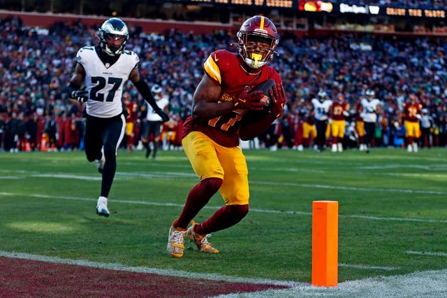 Dec 22, 2024; Landover, Maryland, USA; Washington Commanders wide receiver Terry McLaurin (17) catches a touchdown pass against Philadelphia Eagles cornerback Quinyon Mitchell (27) during the second quarter at Northwest Stadium. Mandatory Credit: Peter Casey-Imagn Images
