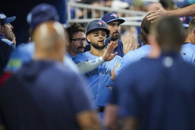 MIAMI, FLORIDA - AUGUST 23: Bo Bichette #11 of the Toronto Blue Jays high fives teammates after scoring during the sixth inning against the Miami Marlins at loanDepot park on August 23, 2025 in Miami, Florida.