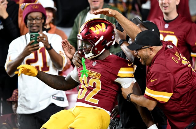 Jacory Croskey-Merritt #32 of the Washington Commanders celebrates with fans after rushing for a touchdown in the first quarter against the Cincinnati Bengals during the NFL Preseason 2025 game on August 18, 2025 in Landover, Maryland.