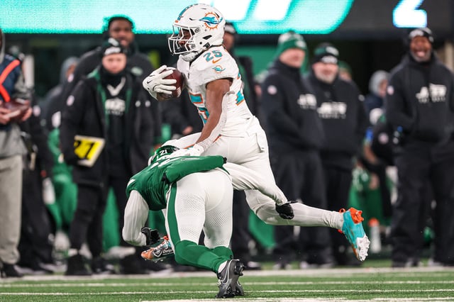 Jan 5, 2025; East Rutherford, New Jersey, USA; Miami Dolphins running back Jaylen Wright (25) fights for yards as New York Jets safety Ashtyn Davis (21) tackles during the second half at MetLife Stadium. Mandatory Credit: Vincent Carchietta-Imagn Images/File Photo