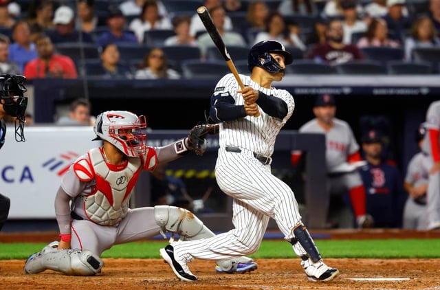 New York Yankees’ Trent Grisham, right, follows through on a home run during the fifth inning of a baseball game against the Boston Red Sox, Sunday, Aug. 24, 2025, in New York. (AP Photo/Noah K. Murray)