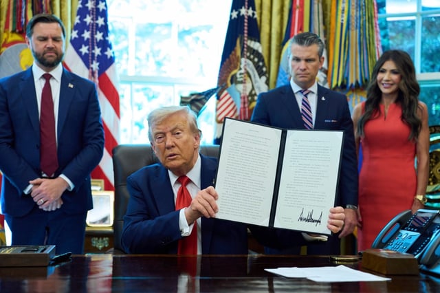 President Donald Trump holds up an executive order on cashless bail as Vice President JD Vance, from left, Defense Secretary Pete Hegseth and Homeland Security Secretary Kristi Noem look on in the Oval Office of the White House, Monday, Aug. 25, 2025, in Washington. (AP Photo/Evan Vucci)