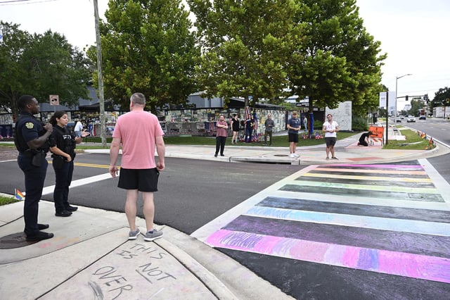 Orlando Police officers warn people not to apply chalk to the crosswalk outside of the Pulse Interim Memorial, Sunday, Aug. 24, 2025, in Orlando, Fla.