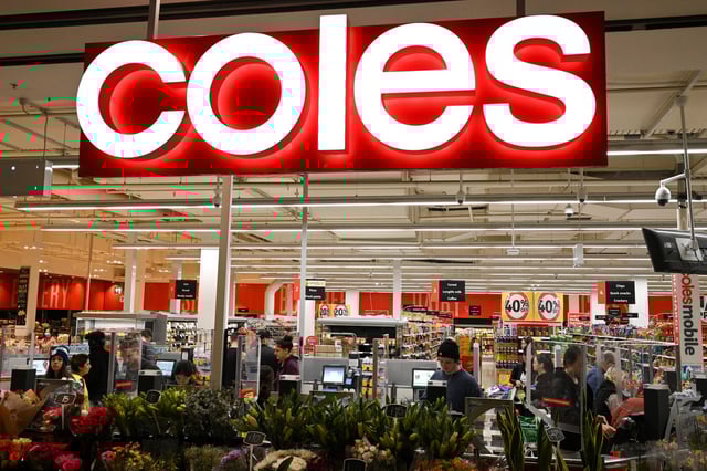 Customers separated by protective plexiglass shields are seen in the self-service checkout area of a Coles supermarket in Sydney, Australia, June 17, 2020. REUTERS/Loren Elliott/File Photo