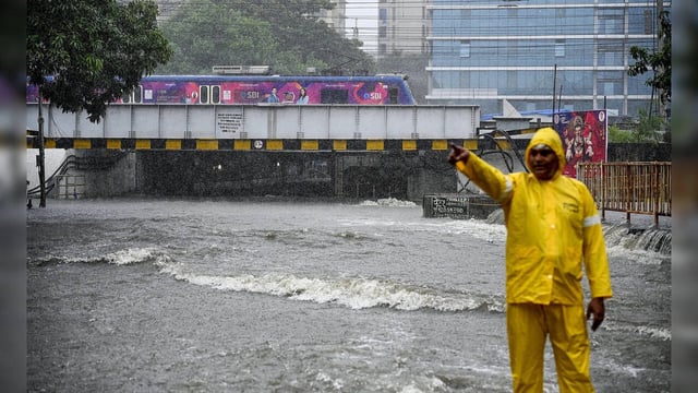 Mumbai: A traffic policeman at the flooded Andheri Subway during heavy rain, in ...