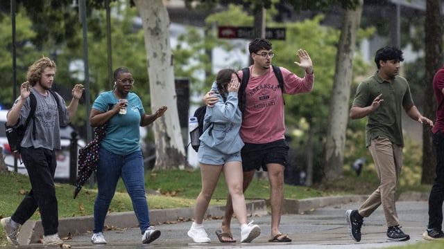 University of Arkansas students and employees evacuate and take shelter on Aug. 25, 2025, in Fayetteville, Ark., as police respond to reports of a shooting.