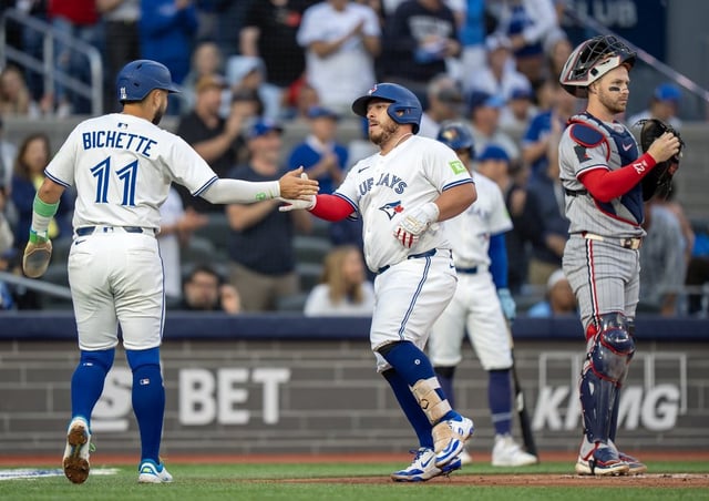 Minnesota Twins catcher Ryan Jeffers (right) stands by as Blue Jays catcher Alejandro Kirk (centre) is congratulated by shortstop Bo Bichette (11) after they scored on Kirk's two-run homer in the first inning of a Major League Baseball game in Toronto on Monday Aug. 25, 2025. THE CANADIAN PRESS/Frank Gunn