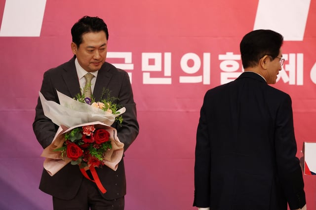 Jang Dong-hyeok, the newly elected leader of the main opposition People Power Party looks on next to his rival candidate Kim Moon-soo during the final round of its convention in Seoul, South Korea, August 26, 2025.   REUTERS/Kim Hong-Ji
