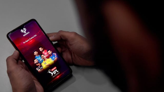 A user checks the Dream11 application of the Indian Premier League (IPL) cricket tournament, on his mobile phone in New Delhi. Parliament has passed a sweeping bill banning online gambling, after government figures showed companies had stripped $2.3 billion annually from 450 million people. 