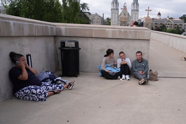 People shelter behind a wall at Villanova University on August 21.