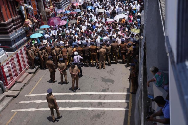 Supporters of arrested former president Ranil Wickremesinghe shout slogans during a protest out side a magistrate's court in Colombo, Sri Lanka, Tuesday, Aug.26, 2025.(AP Photo/Eranga Jayawardena)