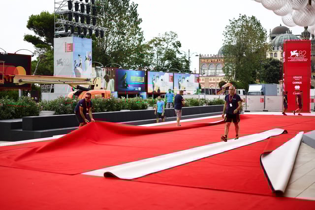 Workers set up the red carpet a day before the start of the 82nd Venice Film Festival in Venice, Italy, August 26, 2025. REUTERS/Yara Nardi