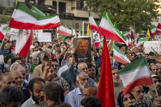 Iranian protesters chant slogans and one holds a poster with a vampire-like illustration of US President Donald Trump in Revolution Square to protest US attacks on nuclear sites in Iran on June 22, 2025 in Tehran, Iran.