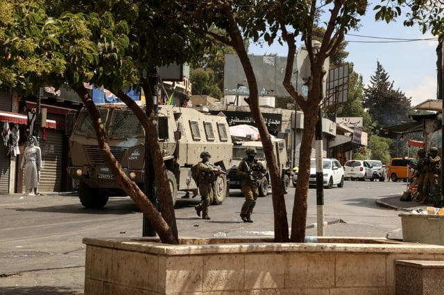 Israeli troops raid the West Bank city of Ramallah, headquarters of the Palestinian Authority.