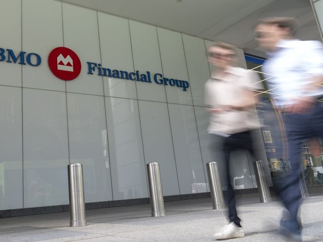 People make their way past the Bank of Montreal (BMO) building in the Financial District of Toronto, Monday, Aug. 14, 2023.