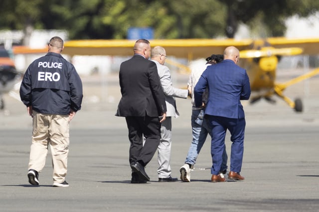 Harjinder Singh is escorted to an airplane by Florida Lt. Gov. Jay Collins and law enforcement on Thursday, Aug. 21, 2025, in Stockton, Calif. (AP Photo/Benjamin Fanjoy)
