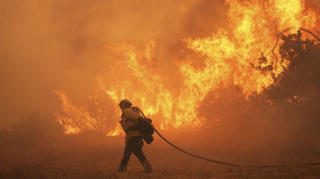 Ein Feuerwehrmann kämpft gegen Flammen im Hasley Canyon, Kalifornien.